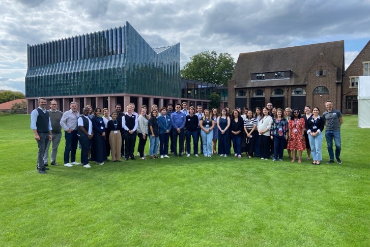 Students standing in a semi-circle for a group photo in front of Homerton College PCSB workshop July 24