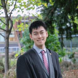 Image of Shaoqian Zhang in Cambridge University robes and suit. 