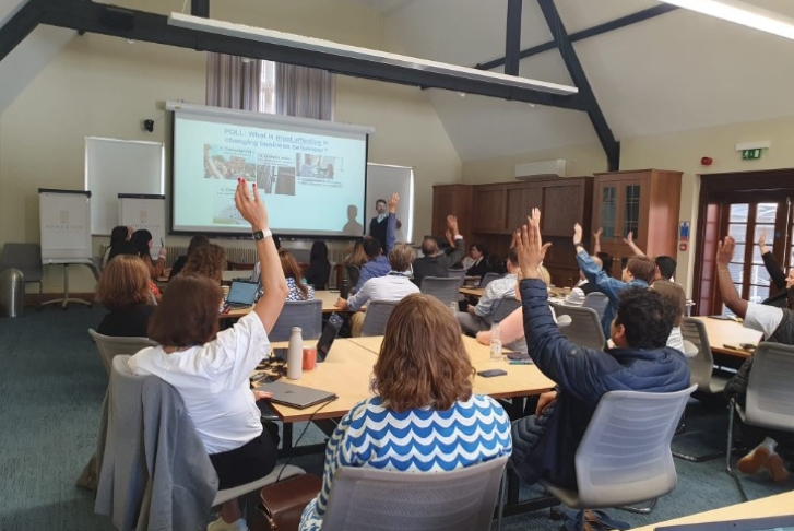 Erinch Sahan asking students to raise their hands in a poll in a classroom setting