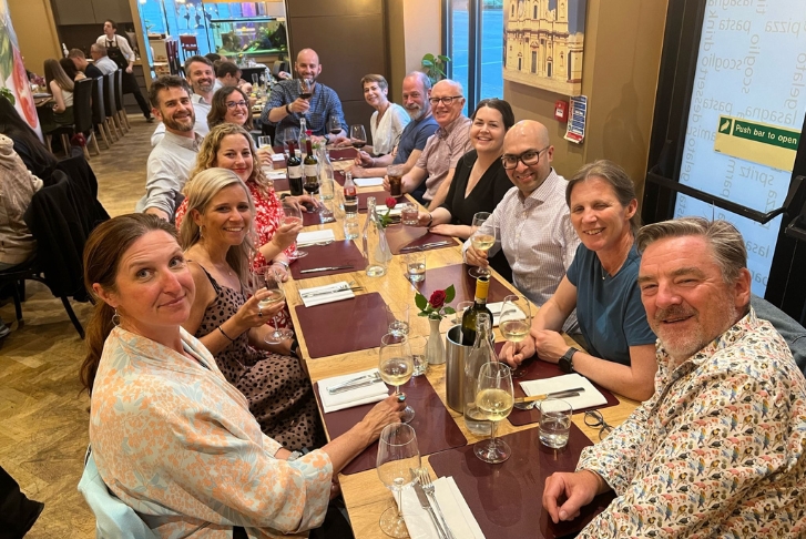 Course directors and supervisors at their post workshop dinner July 24 Course directors and supervisors sat at a long table in a restaurant waiting for their post workshop dinner