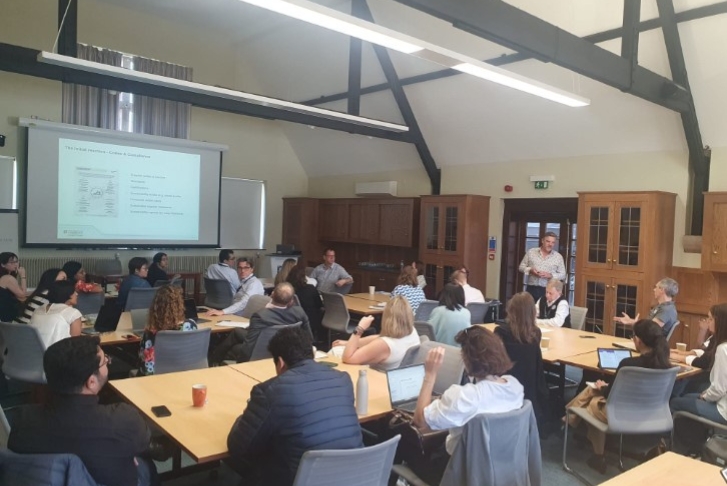 Students sat in a classroom setting with the lecturer David Lawrence walking around the students
