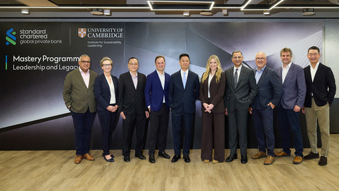 A group of ten people in professional business attire stand in front of a branded backdrop featuring the logos of Standard Chartered Global Private Bank and the University of Cambridge Institute for Sustainability Leadership, with the text “Mastery Programme Leadership and Legacy.”