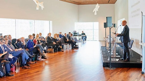 Professional seminar with speaker at podium, business audience, and modern conference setup.