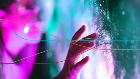 Close-up of a hand touching a brightly lit, textured surface with glowing pink and teal lights in the background, overlaid by several thin, multicoloured curved lines