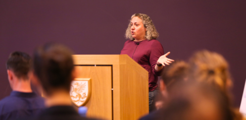 Dr Kayla Friedman presenting behind a lectern to a group of students
