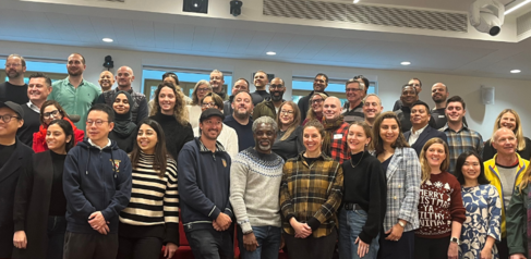 Group of Sustainable Built Environment Students standing on lecture hall steps