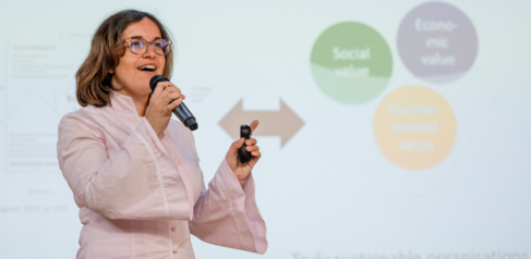 Dr Tanja Collavo stood in front of a presentation 