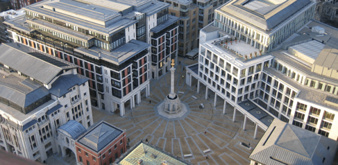 Plaza in a city with monument in the middle.