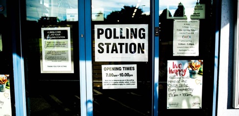 Doors of community centre with 'Polling Station' signs