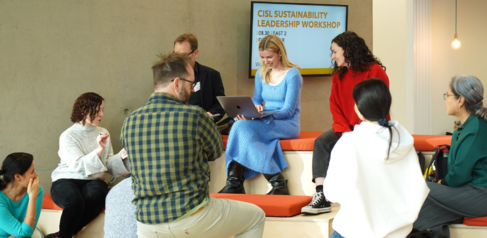A group of students sat and stood around tiered seating 