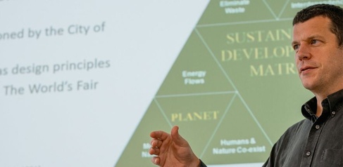 Tim Forman stood in front of a presentation with a triangle behind him. 