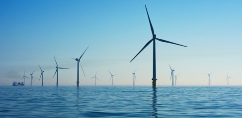 Wind turbines standing in blue sea off the coast of southern England