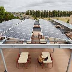 Solar panels on roof of Entopia Building, with person working at table underneath