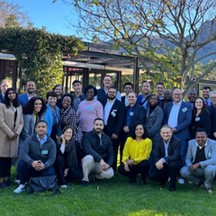 Participants of the G20 Sustainable Finance Working Group stand in a row on a grassy lawn.