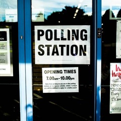 Doors of community centre with 'Polling Station' signs