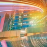 Modern city skyline with illuminated office buildings and dynamic light trails representing innovation, digital transformation, future markets and sustainable economic growth.