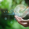 Illustration of a hand supporting a glowing circular arrow icon symbolising product traceability, resource reuse, and circular economy practices.