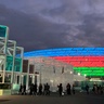 COP29 venue at stadium in Baku, lit up at night in Azerbaijan colours