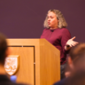 Dr Kayla Friedman presenting behind a lectern to a group of students