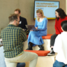 Eight students sat on a mixed level seating area discussing their work