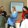 Seven students sat and stood in a circle working on a presentation