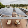 Solar panels on roof of Entopia Building, with person working at table underneath