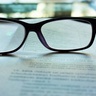 Pair of spectacles resting on top of typed papers