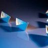 Paper boats forming the letter V (Victory)