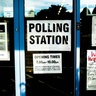 Doors of community centre with 'Polling Station' signs