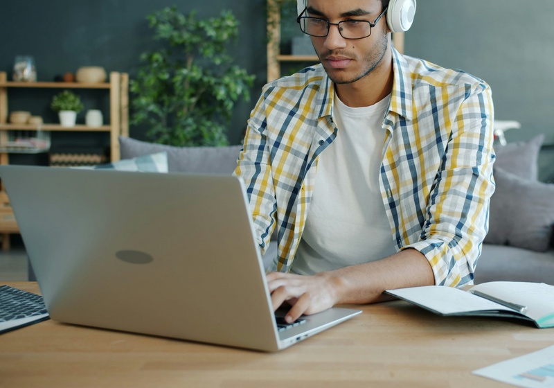 Man wearing glasses and headphones. Focused on studying.