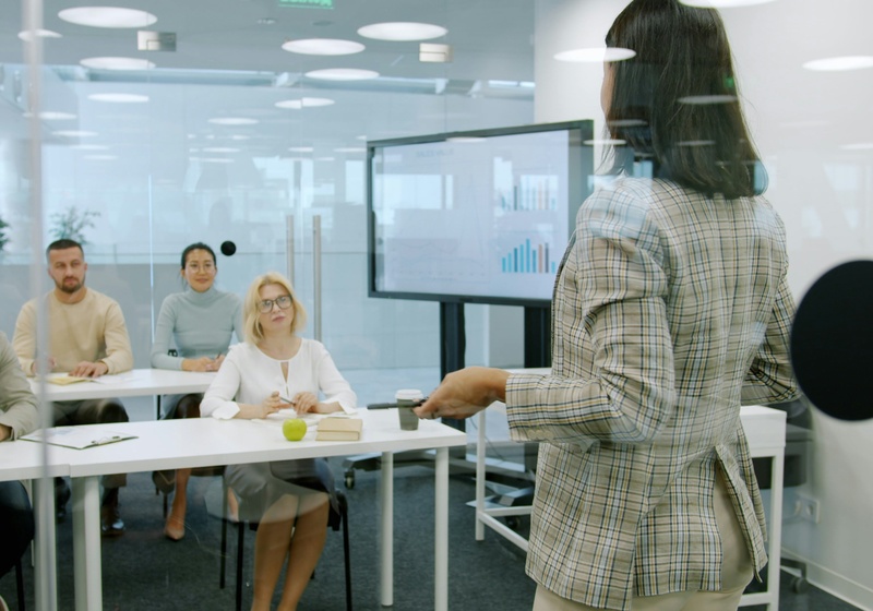 Woman presenting in front of five colleagues