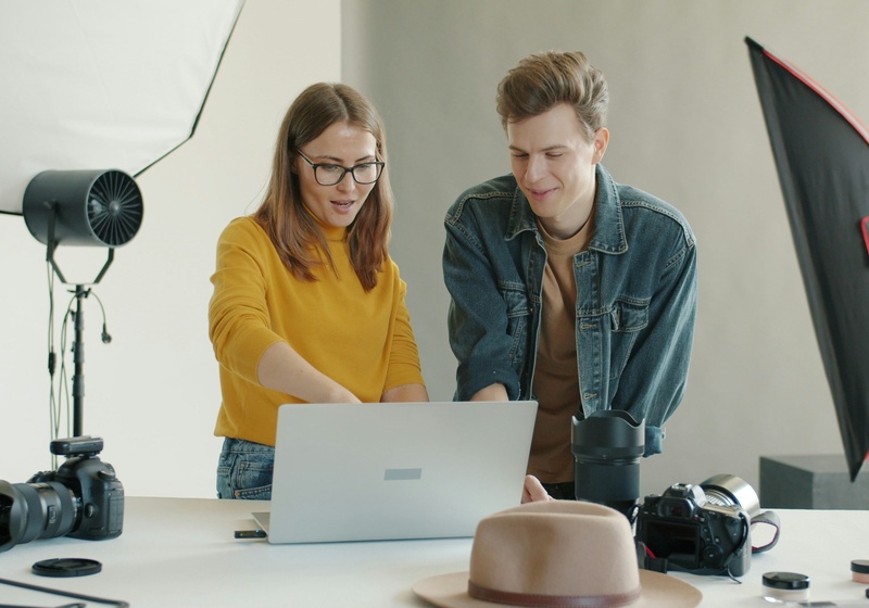 Young man and woman discussing outcome of a photoshoot on the computer