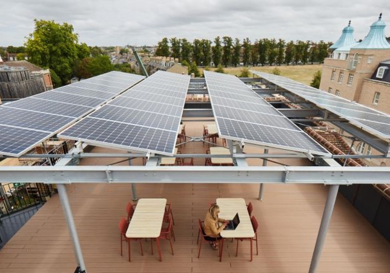 Solar panels on roof of Entopia Building, with person working at table underneath