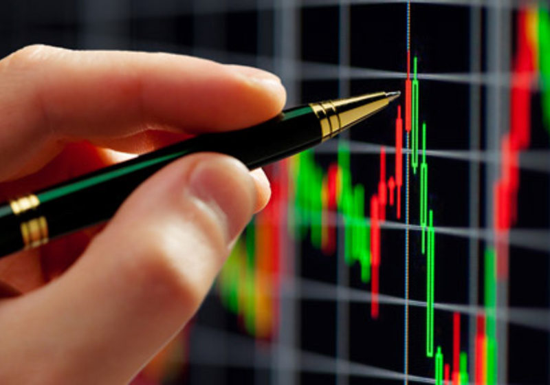 Pen pointing at stock graphs