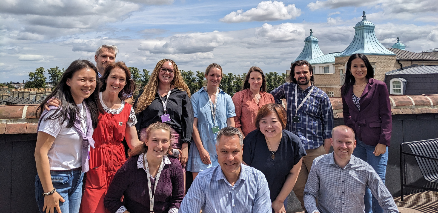 It's a sunny day in Cambridge, and a team of people are smiling at a camera, whilst stood on a on a roof top terrace. There's a mix of men and women from all different backgrounds, it's the Canopy team from CISL.