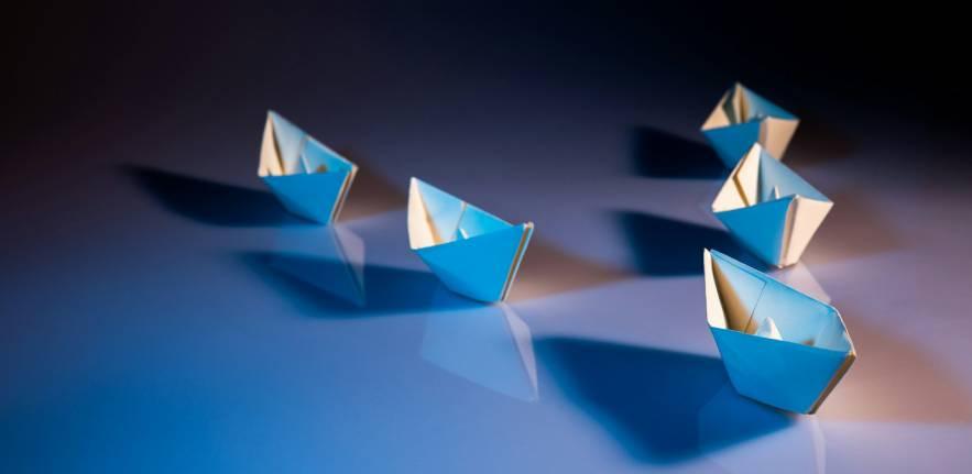 Paper boats forming the letter V (Victory)