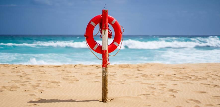 Lifebelt fixed to post on sunny beach