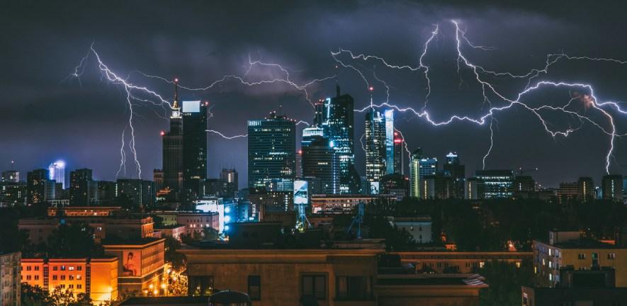 Cityscape at night with flashes of lightning over skyscrapers Cityscape at night with flashes of lightning over skyscrapers