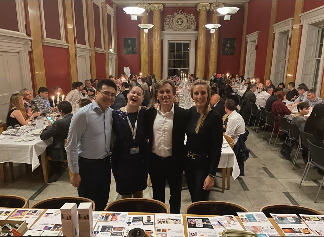 Henry Kong with Sustainable Business Course Directors and Colleagues in front of fellow students in a college dining hall