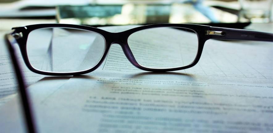 Pair of spectacles resting on top of typed papers